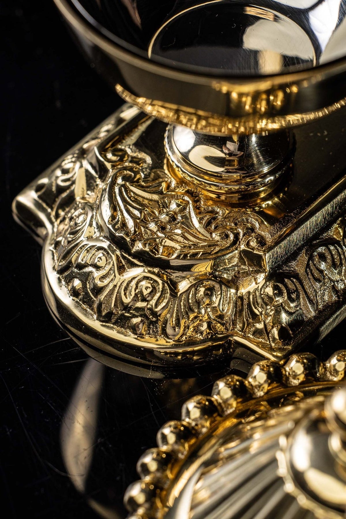 Purificator holder detail showing raised scrollwork on the decorative base