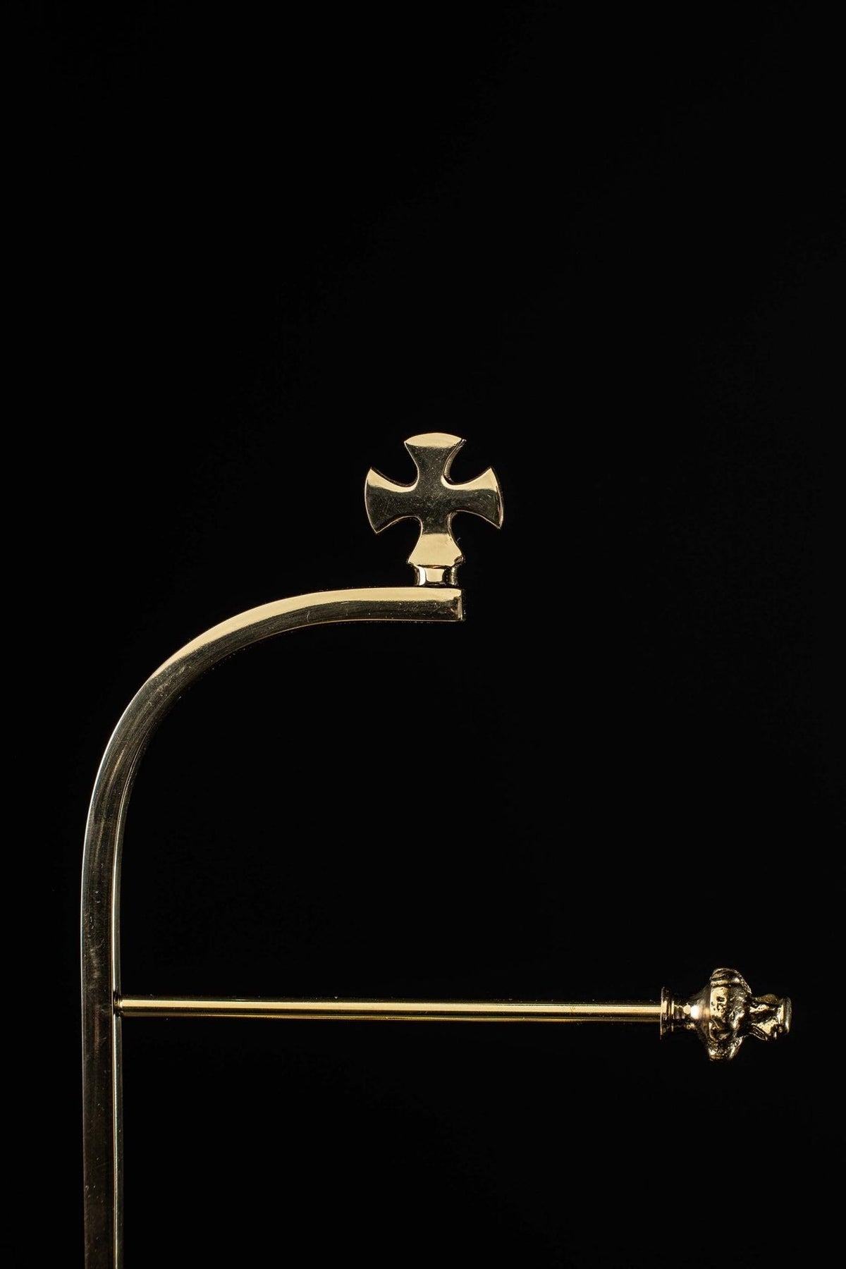 Purificator holder close-up showing the cross finial and curved support