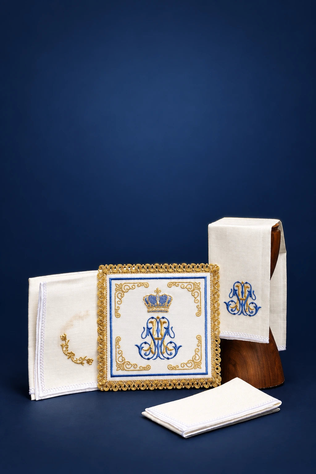 Altar linen set with embroidered Marian monogram and gold border, including folded purificator and corporal holders