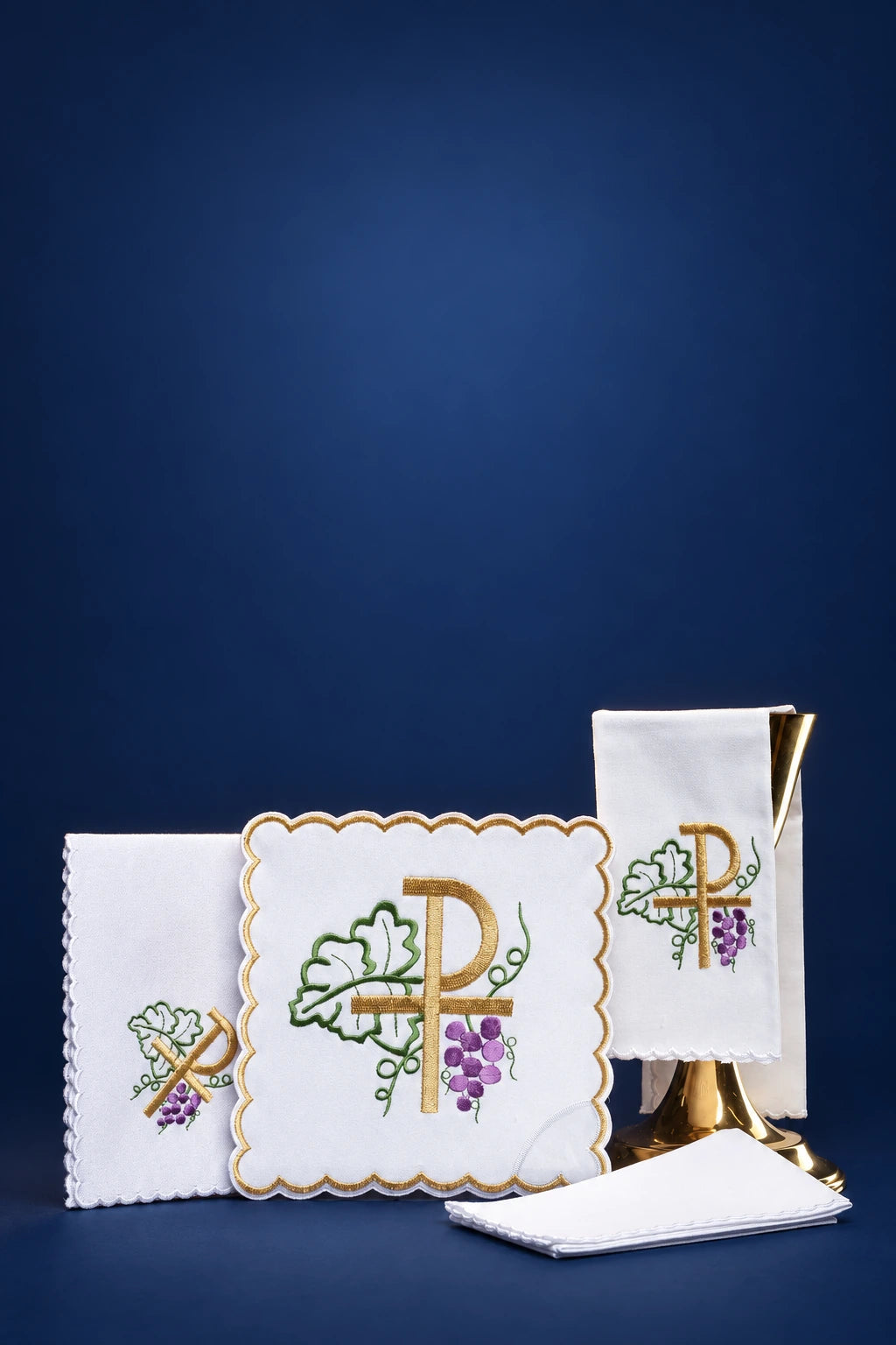 Altar linen set with embroidered PAX and grapes, shown with purificator, pall, corporal and towel folded together
