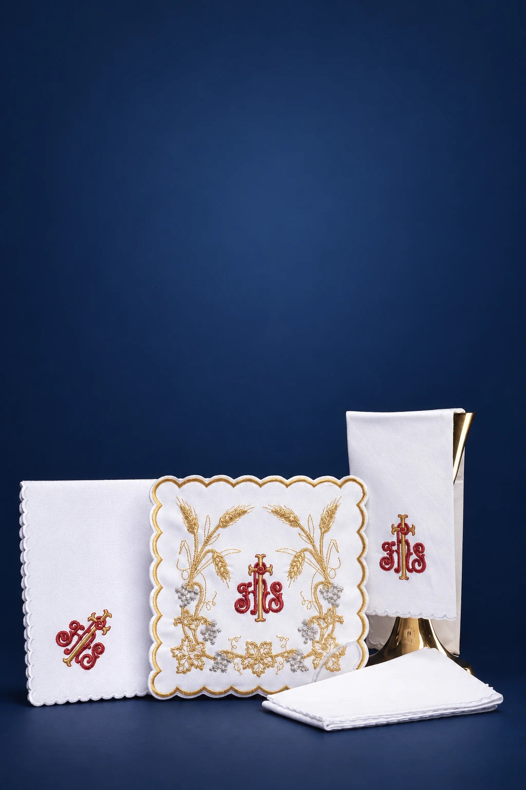 Altar linen set with scalloped pall, corporal, purificator and folded cloths, embroidered with IHS and wheat motifs