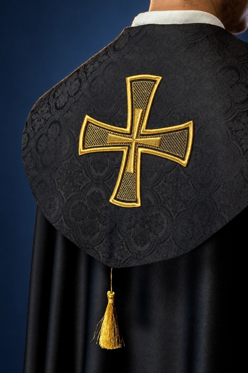 Back view of black cope with gold cross embroidery on jacquard, with tassel tie closure