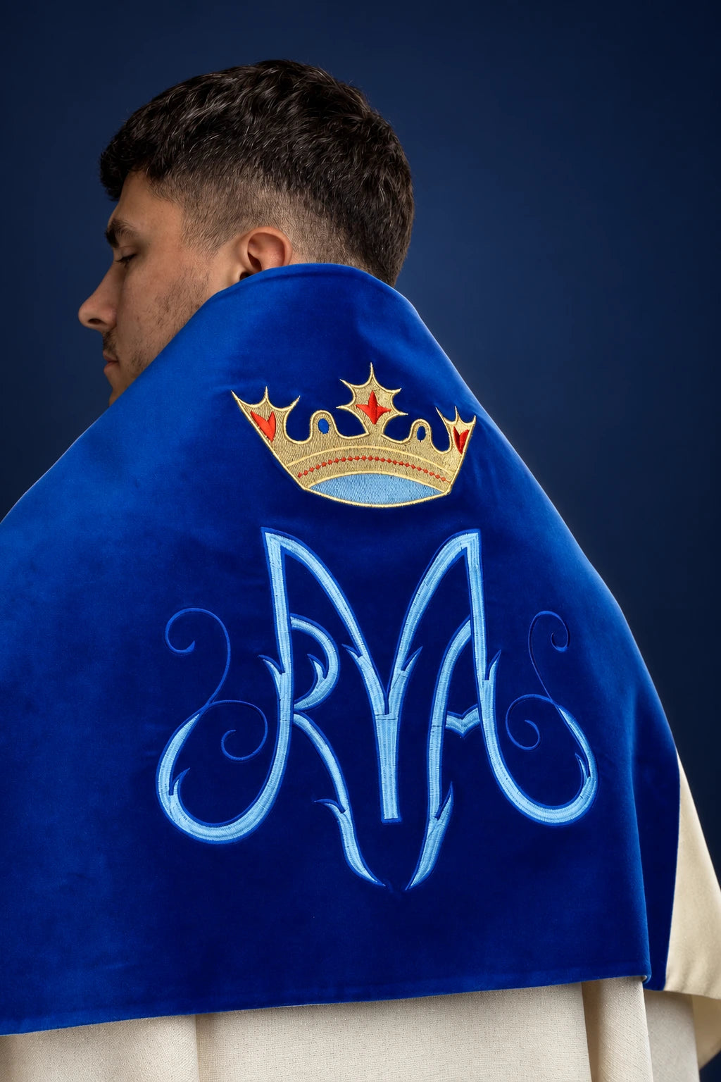 Back view of a blue velvet humeral veil with embroidered Marian symbol and crown motif
