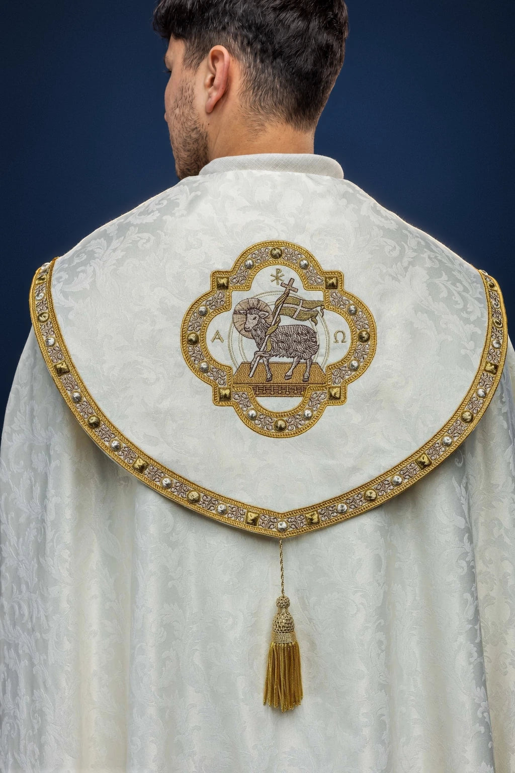 Back view of an ecru cope with Paschal Lamb medallion and gold-trimmed hood capelet tassel