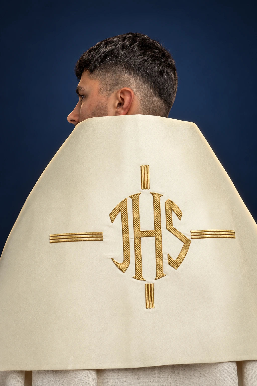 Back view of an ecru humeral veil with central IHS embroidery and gold bars on the back