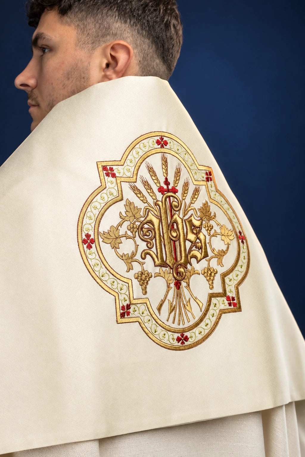 Back view of an ecru humeral veil with ornate embroidered IHS medallion on the back panel