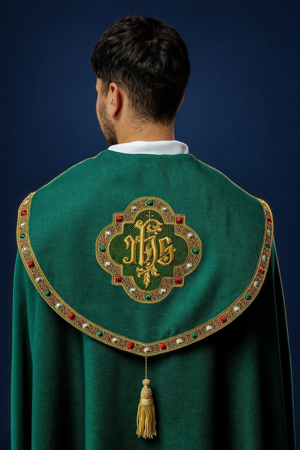 Back view of a green cope with gold IHS embroidery and jeweled trim, fastened with a gold tassel cord