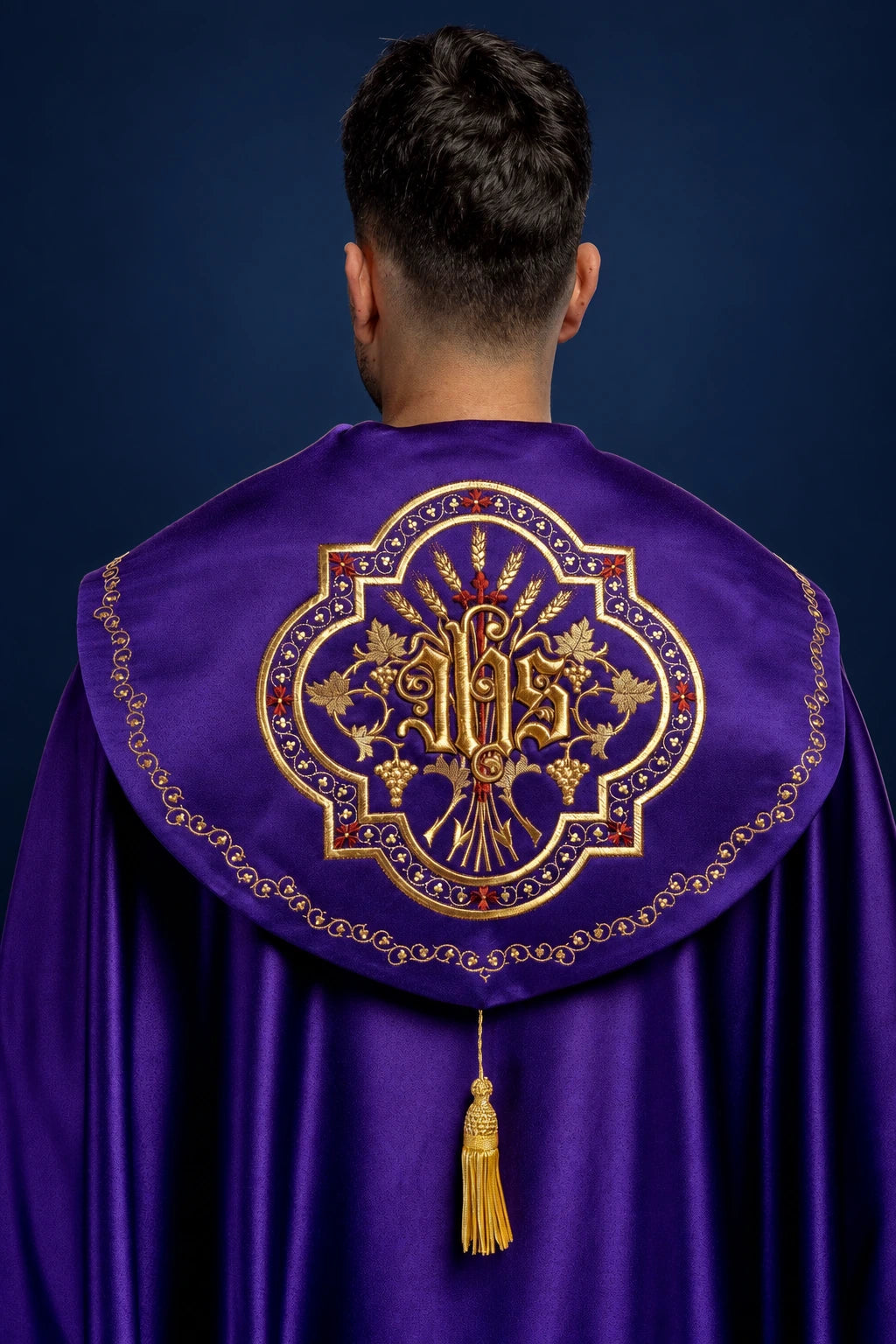 Back view of a purple Eucharistic cope with ornate gold monogram and tassel clasp