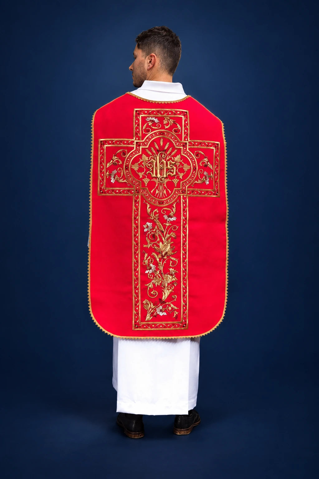 Back view of a red Roman chasuble with gold embroidered cross and IHS motif
