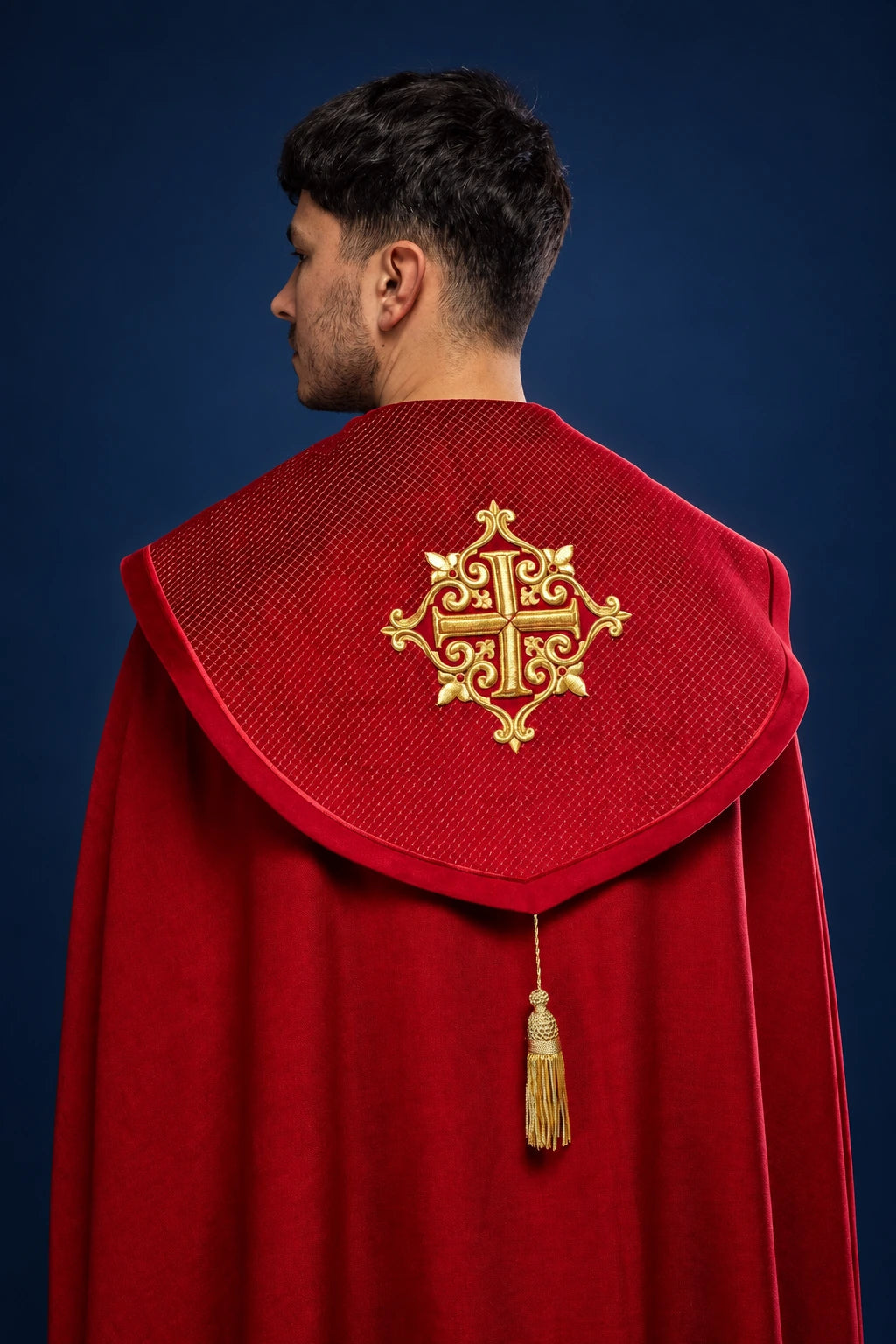 Back view of a red velvet cope with gold cross embroidery and hanging tassel closure