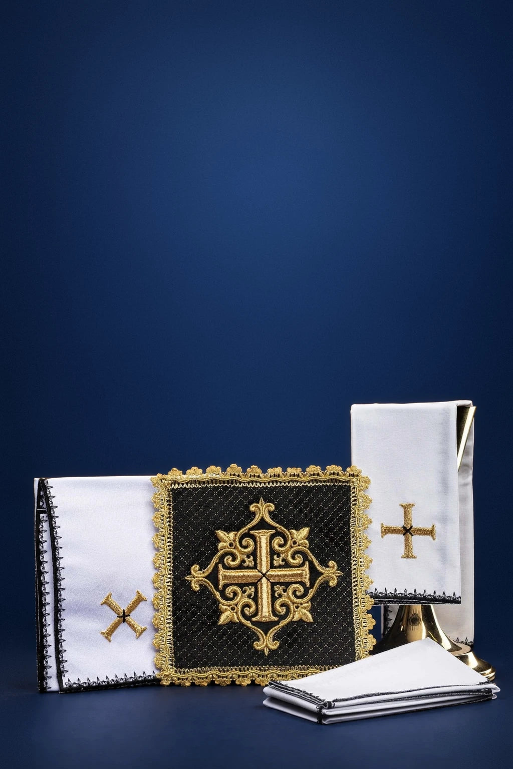 Black altar linen set with embroidered cross and gold-edged burse on folded linens, front view