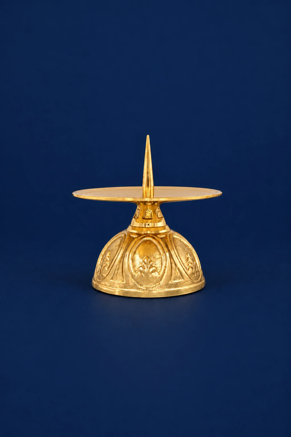 Brass candlestick, front view, with pointed stem and embossed floral base