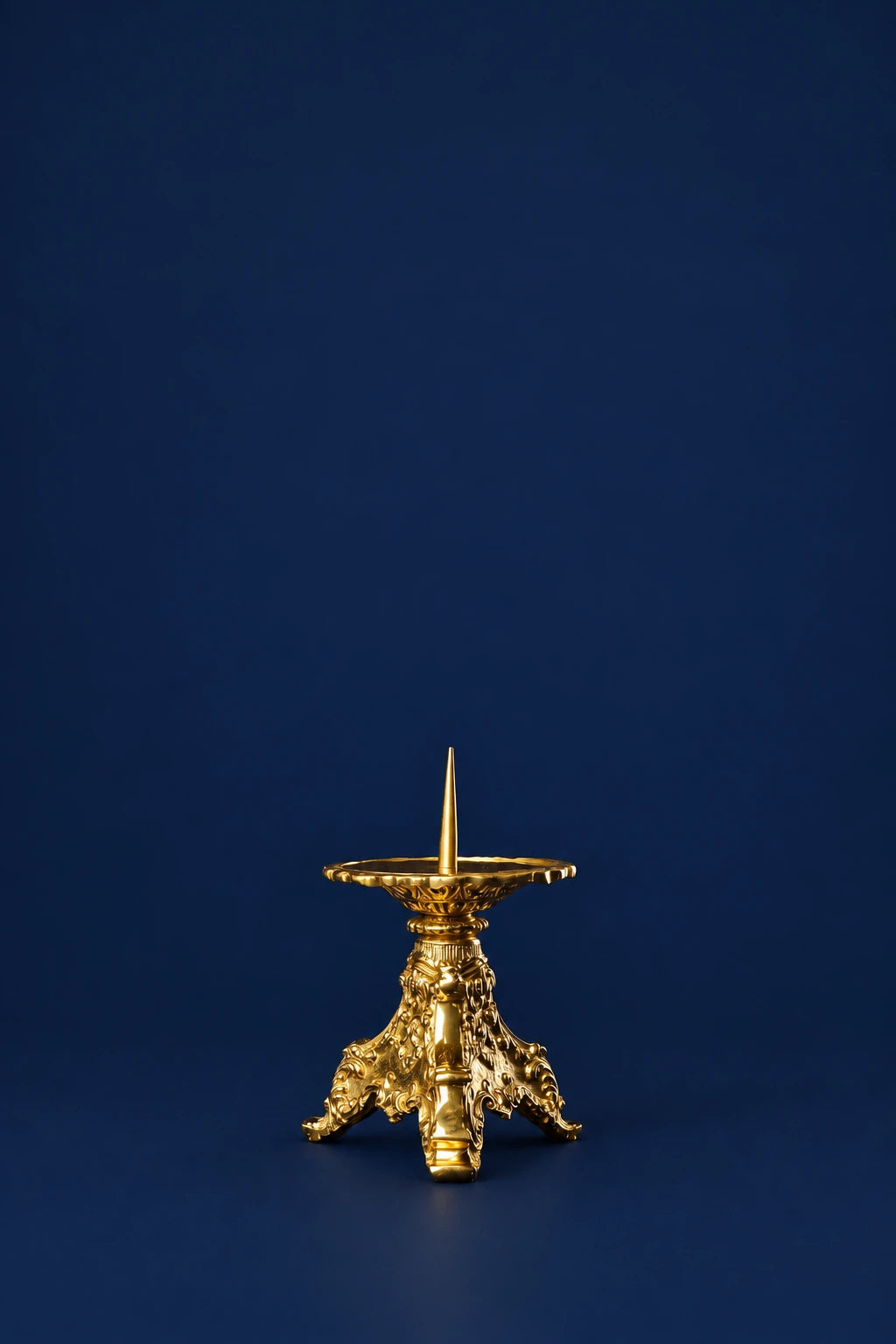 Brass candlestick with ornate three-legged base, front view