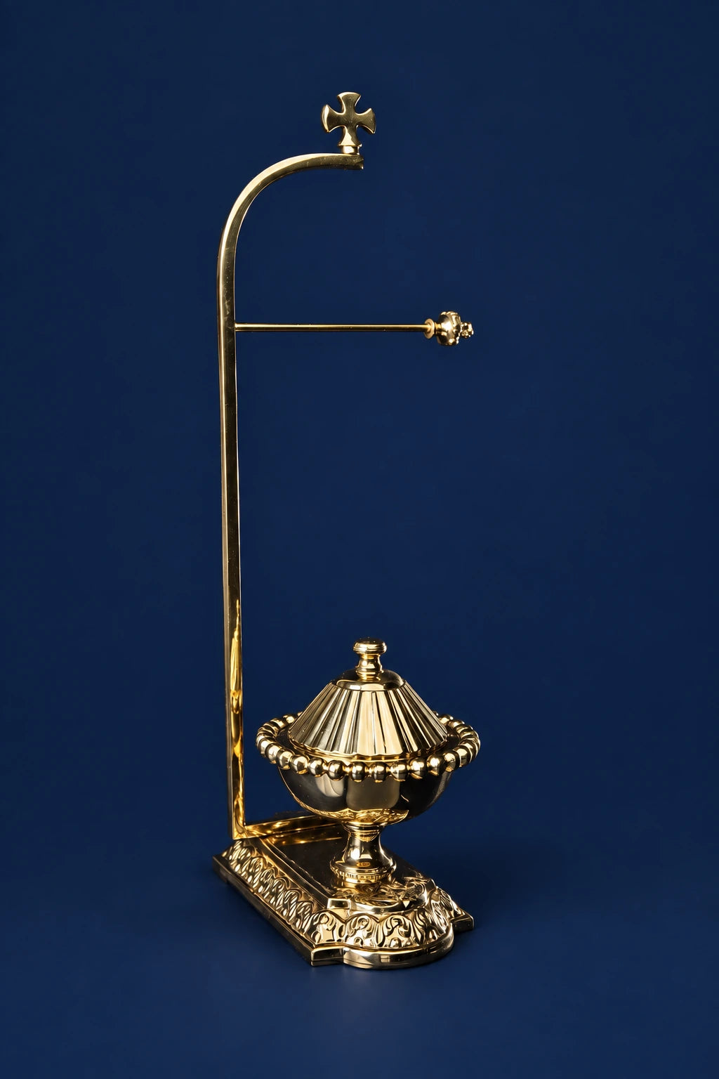 Brass purificator holder with decorative base, side arm, and cross finial, front view