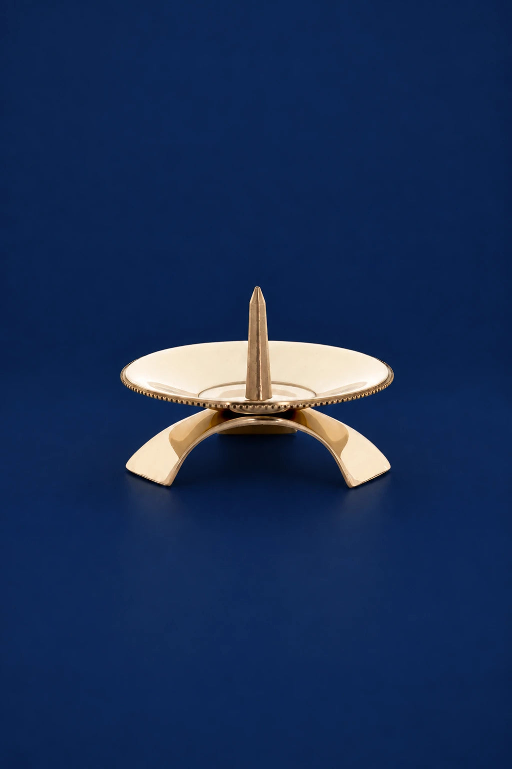 Brass Candlestick, 1.25 in (3 cm), front view with a wide drip tray and arched base
