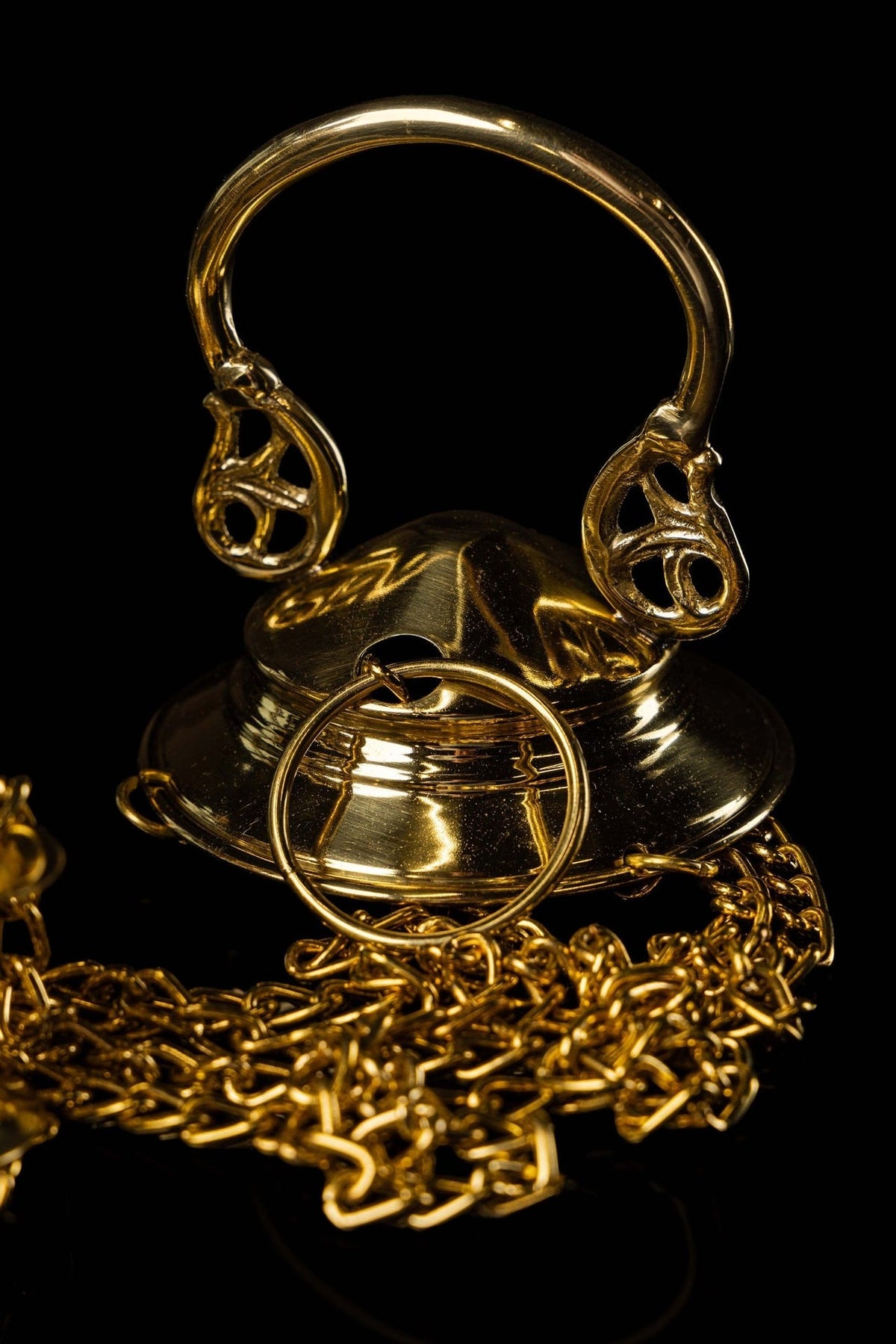 Brass thurible close-up showing ornate lid, chains and openwork scrolls