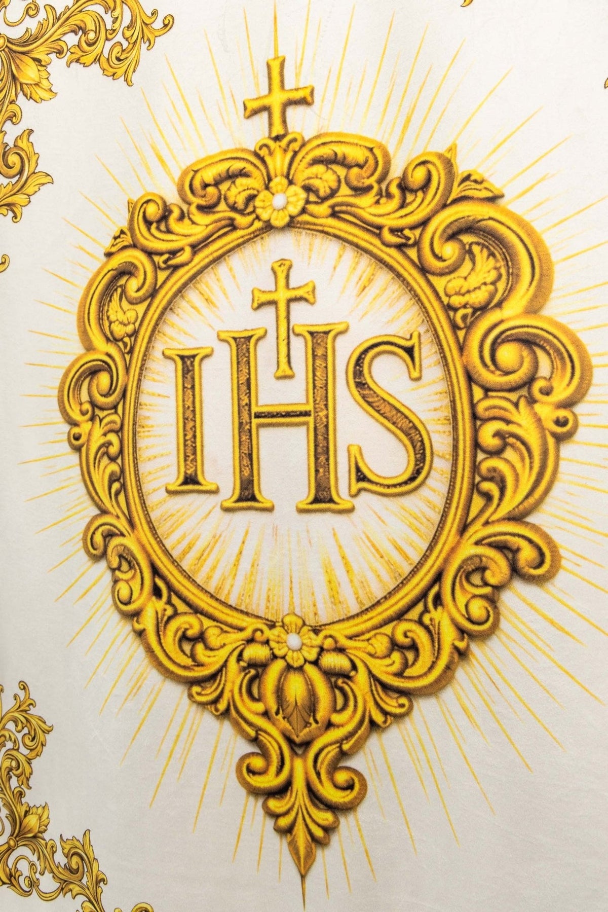 Church banner with IHS, close-up of gold baroque frame and cross on white fabric