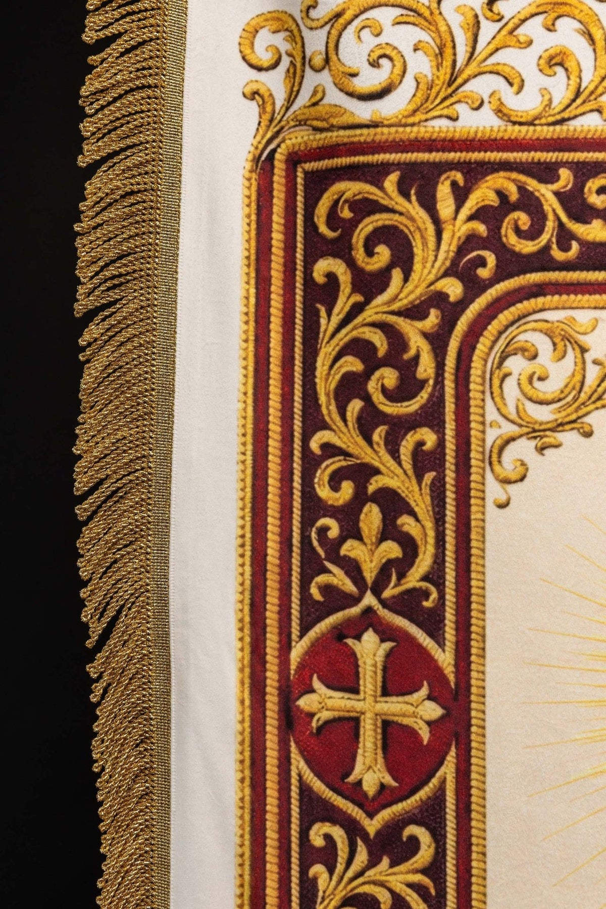 Church banner close-up showing ornate gold, burgundy and white printed border with cross