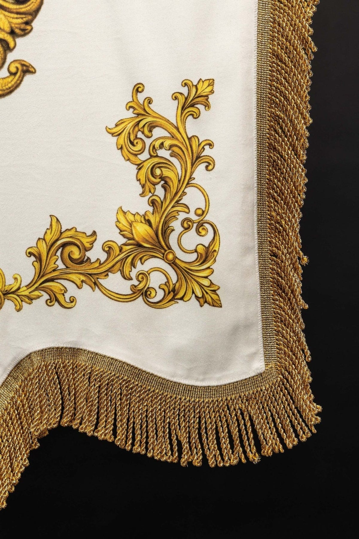 Church banner top corner with white fabric, gold fringe and finial