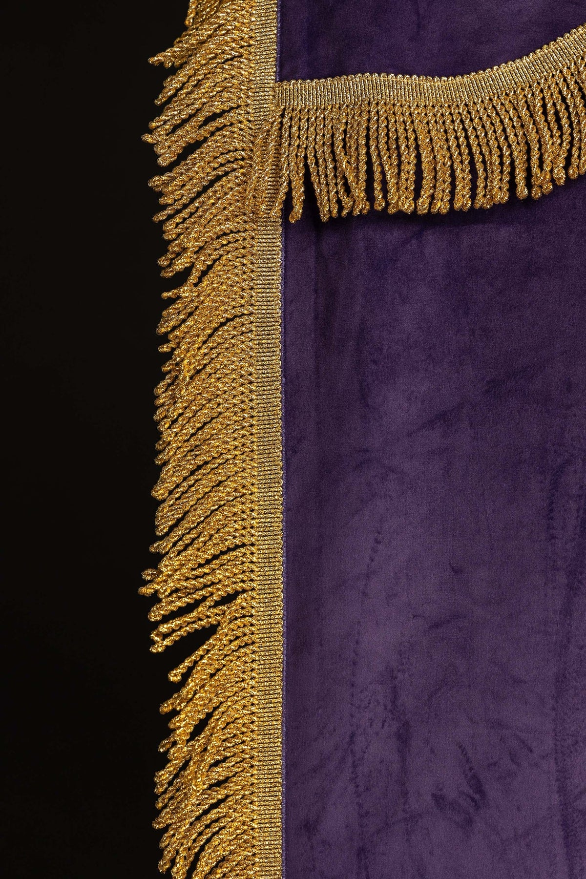 Church banner close-up showing gold fringe at the side and top