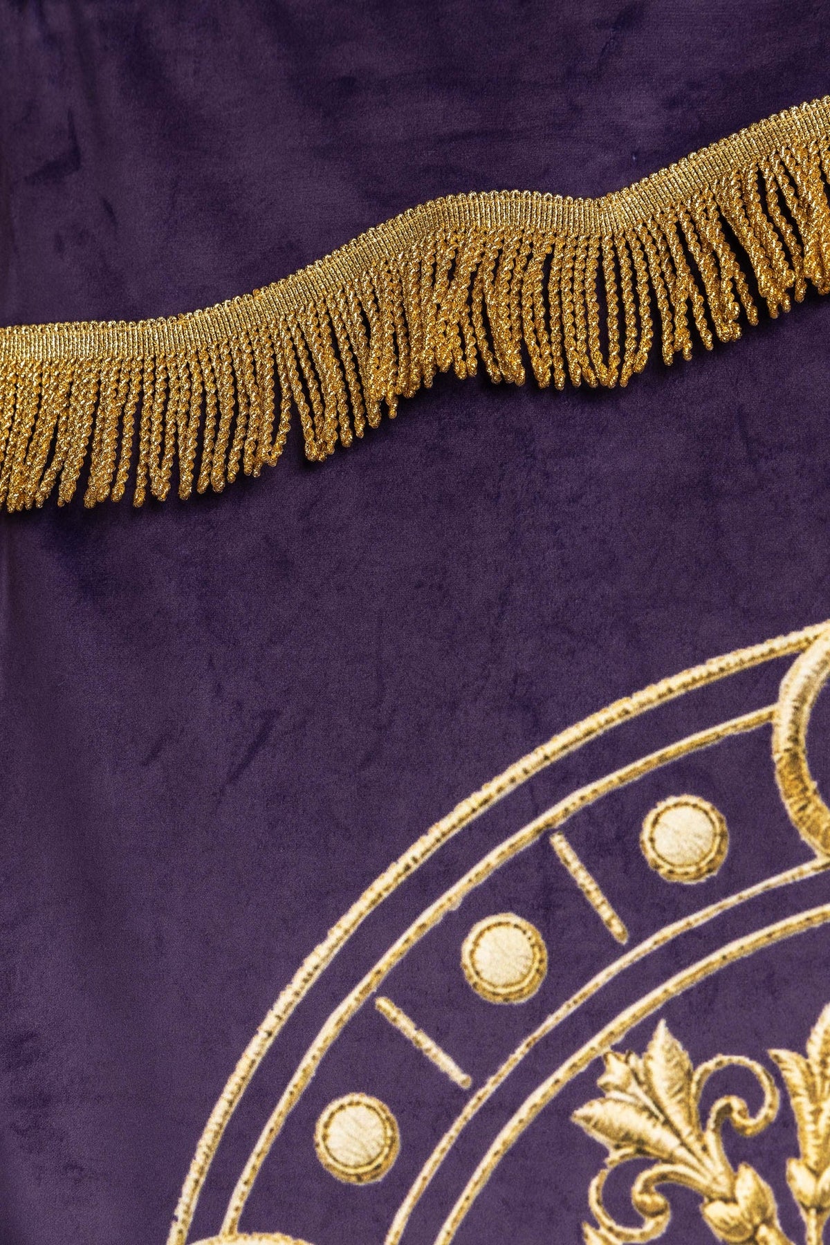 Church banner close-up showing gold fringe over purple fabric