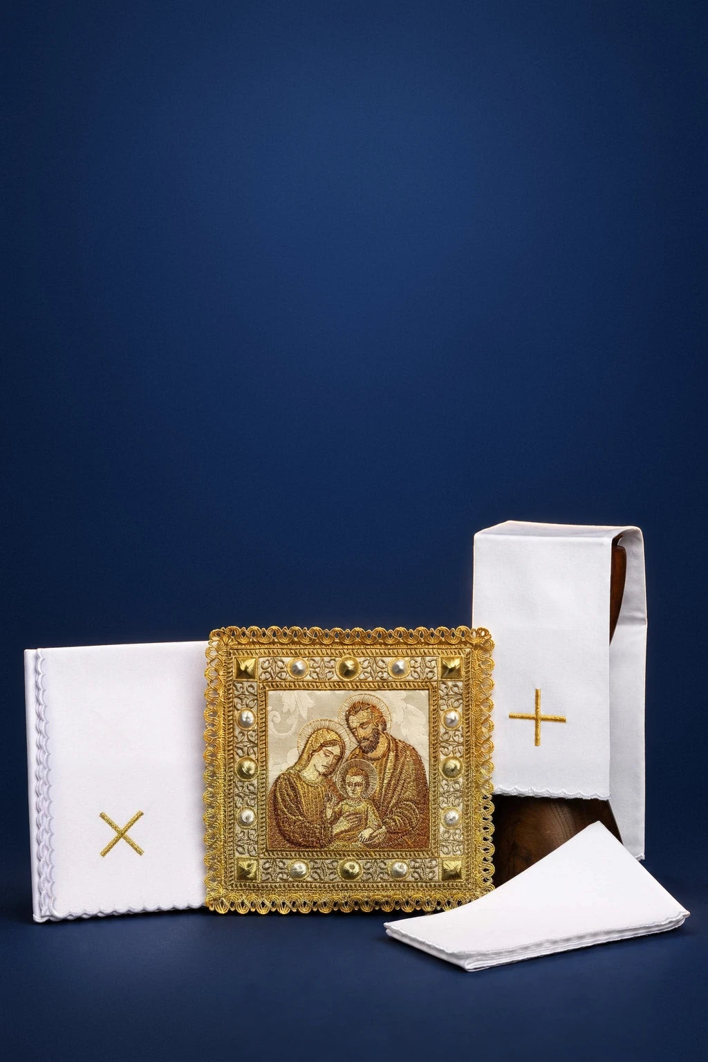 Christmas altar linen set with Holy Family image and gold cross embroidery, arranged folded and square-fronted