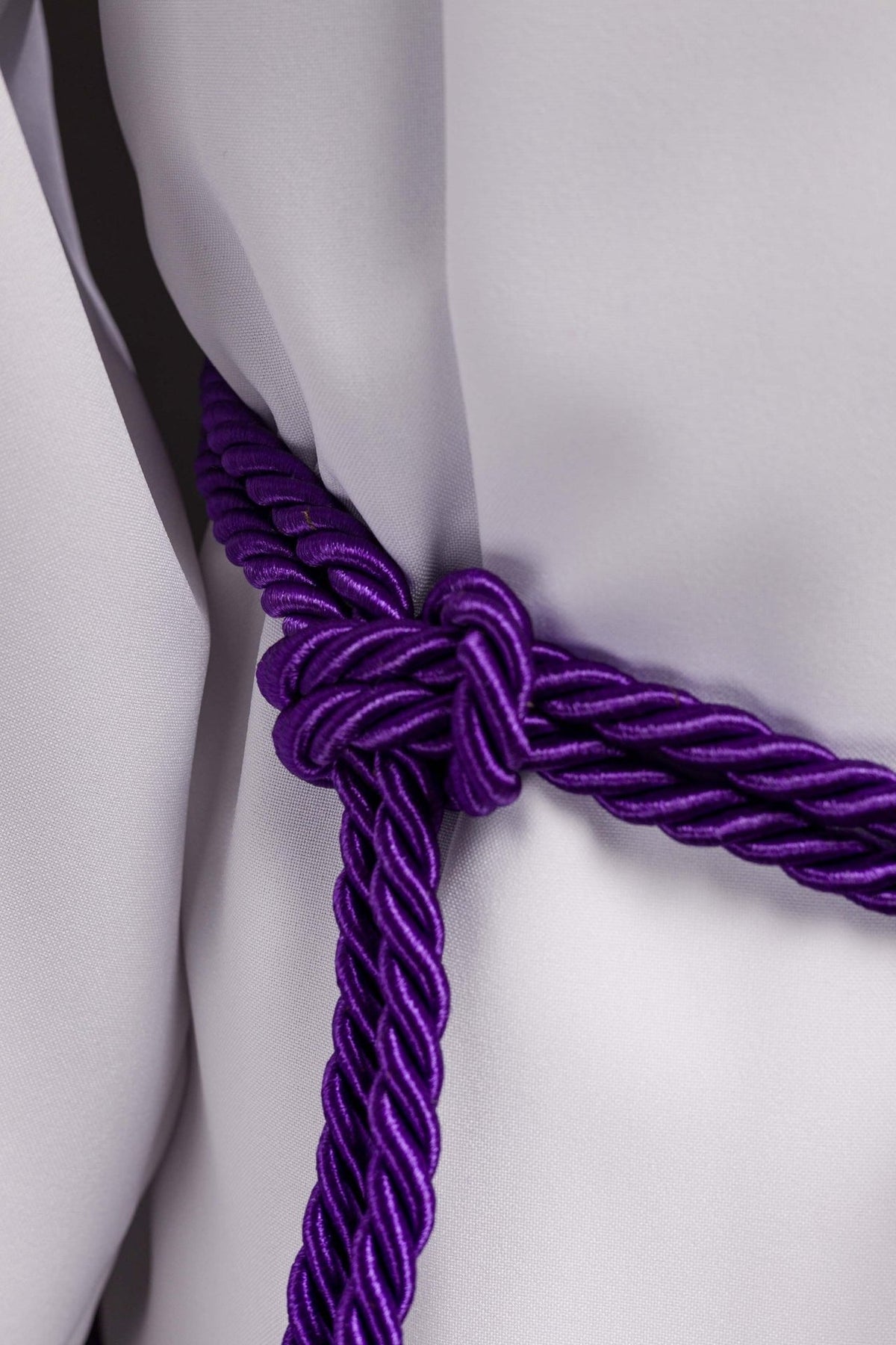 Purple cincture close-up showing braided knot and cord finish