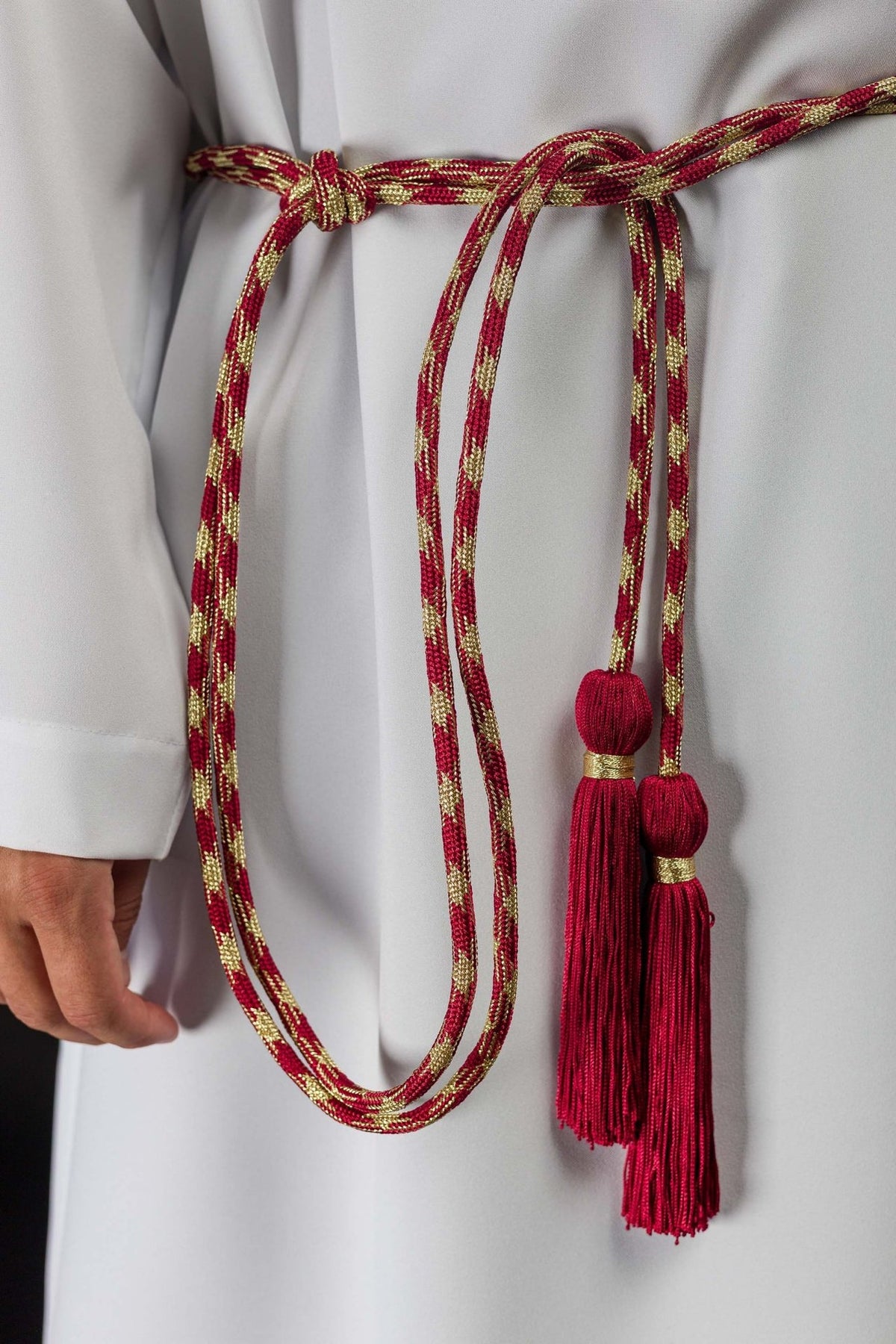 Red and Gold Liturgical Cincture worn around an alb, with braided cords and red tassels