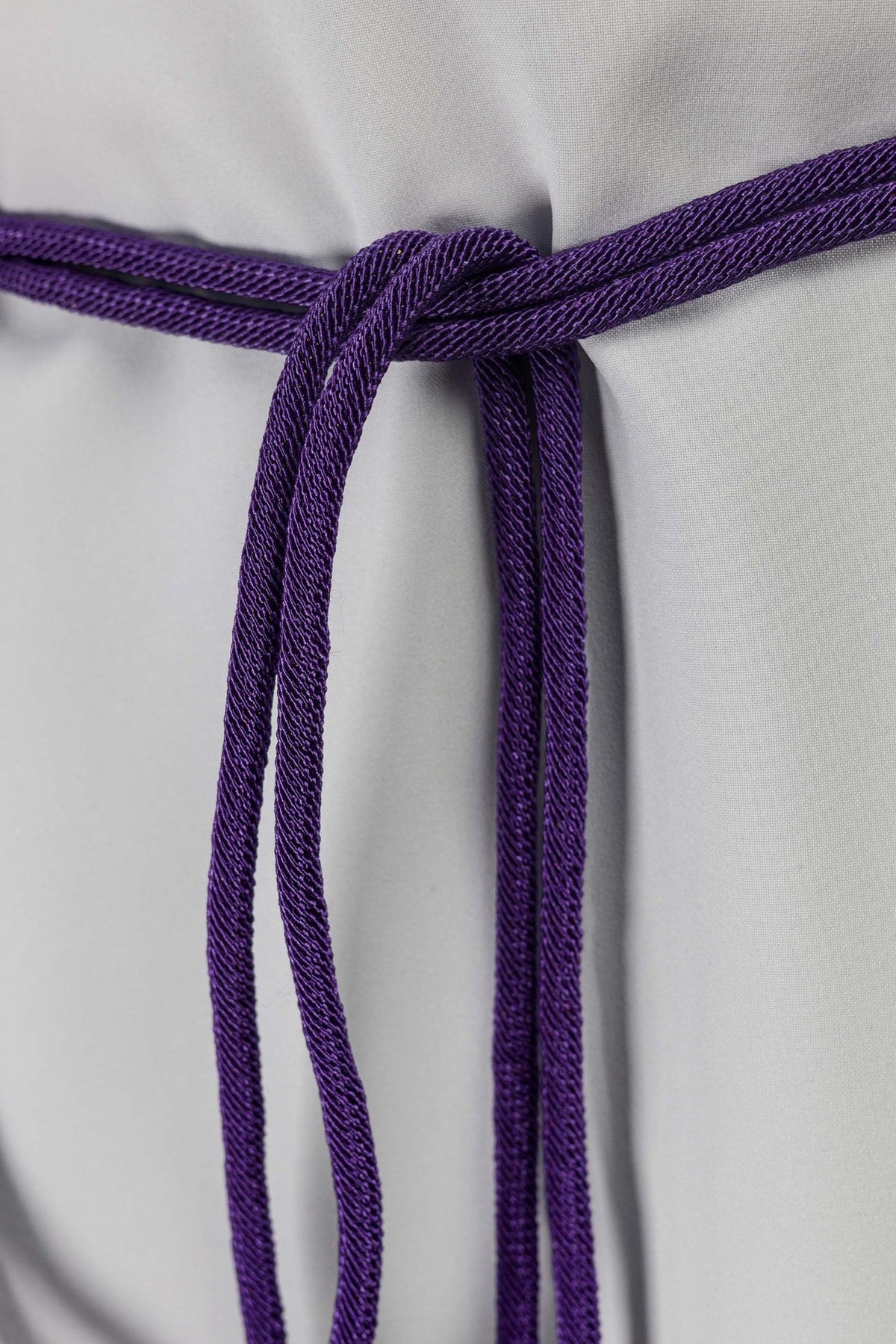 Purple cincture close-up showing braided cord and central knot
