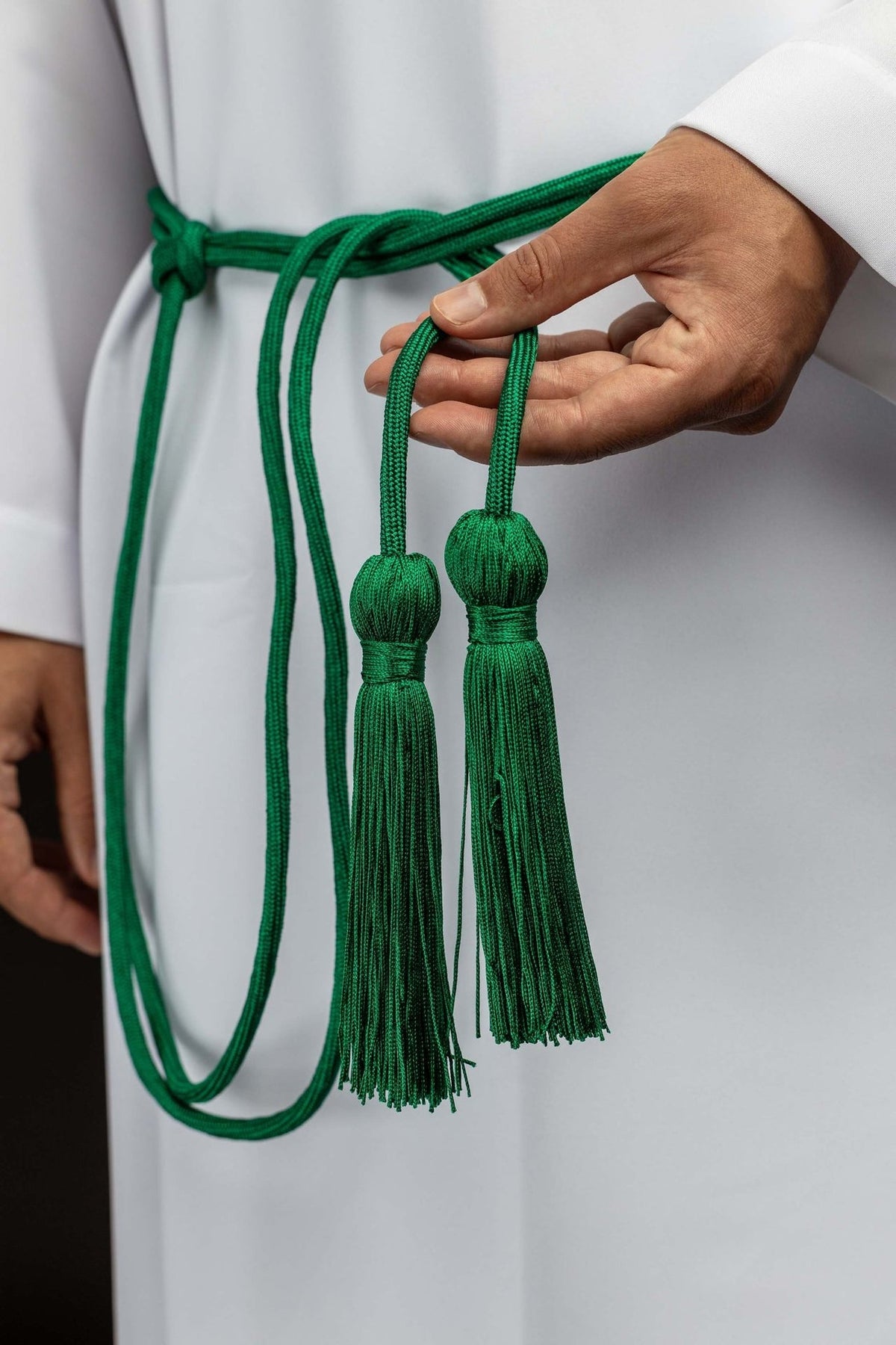 Green cincture close-up showing two decorative tassels