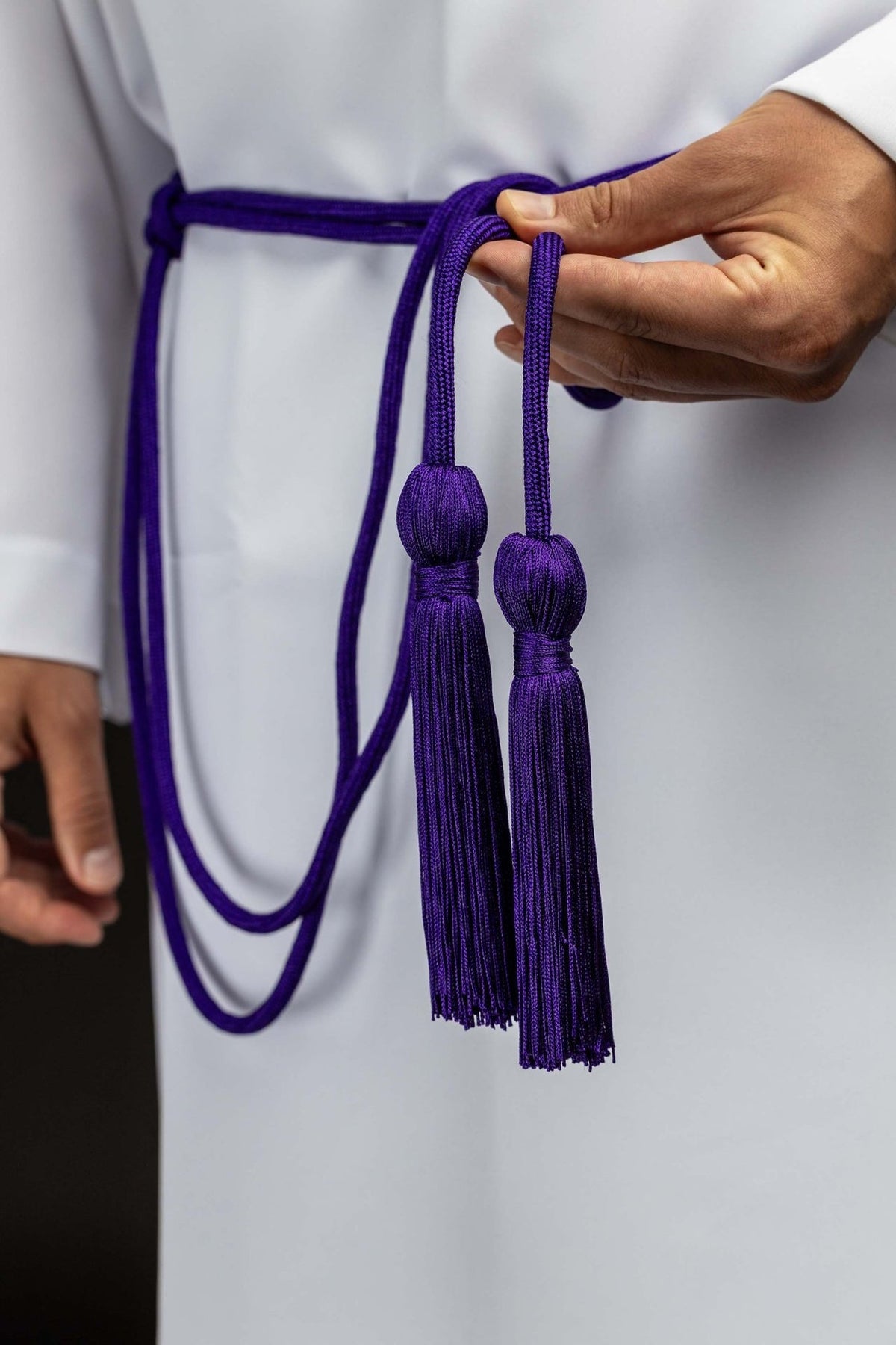 Purple cincture worn with two long tassels hanging at the front