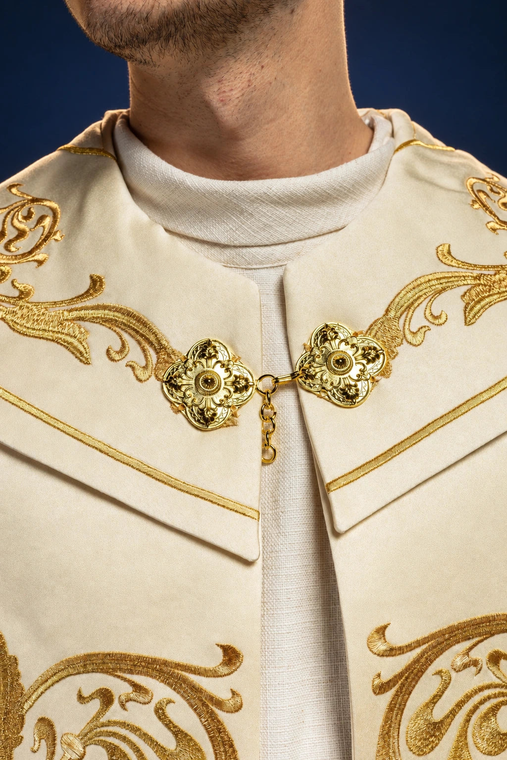 Close-up of the cope front collar with gold embroidered scrollwork and jeweled clasp details