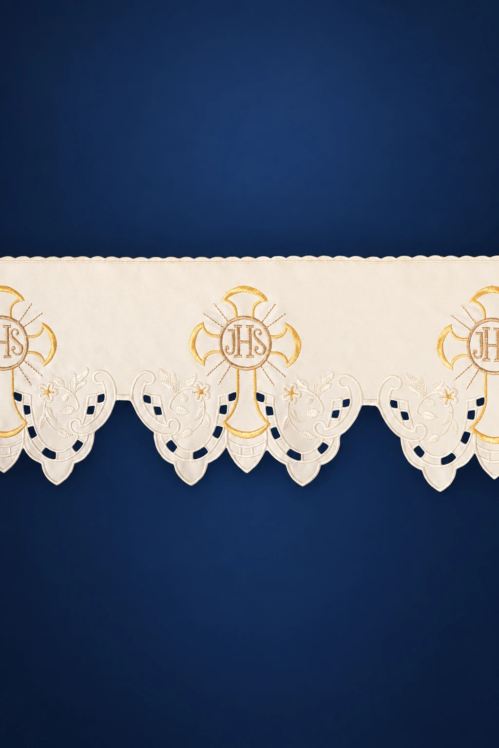 Close-up of ecru altar lace with scalloped edging and repeating IHS cross embroidery