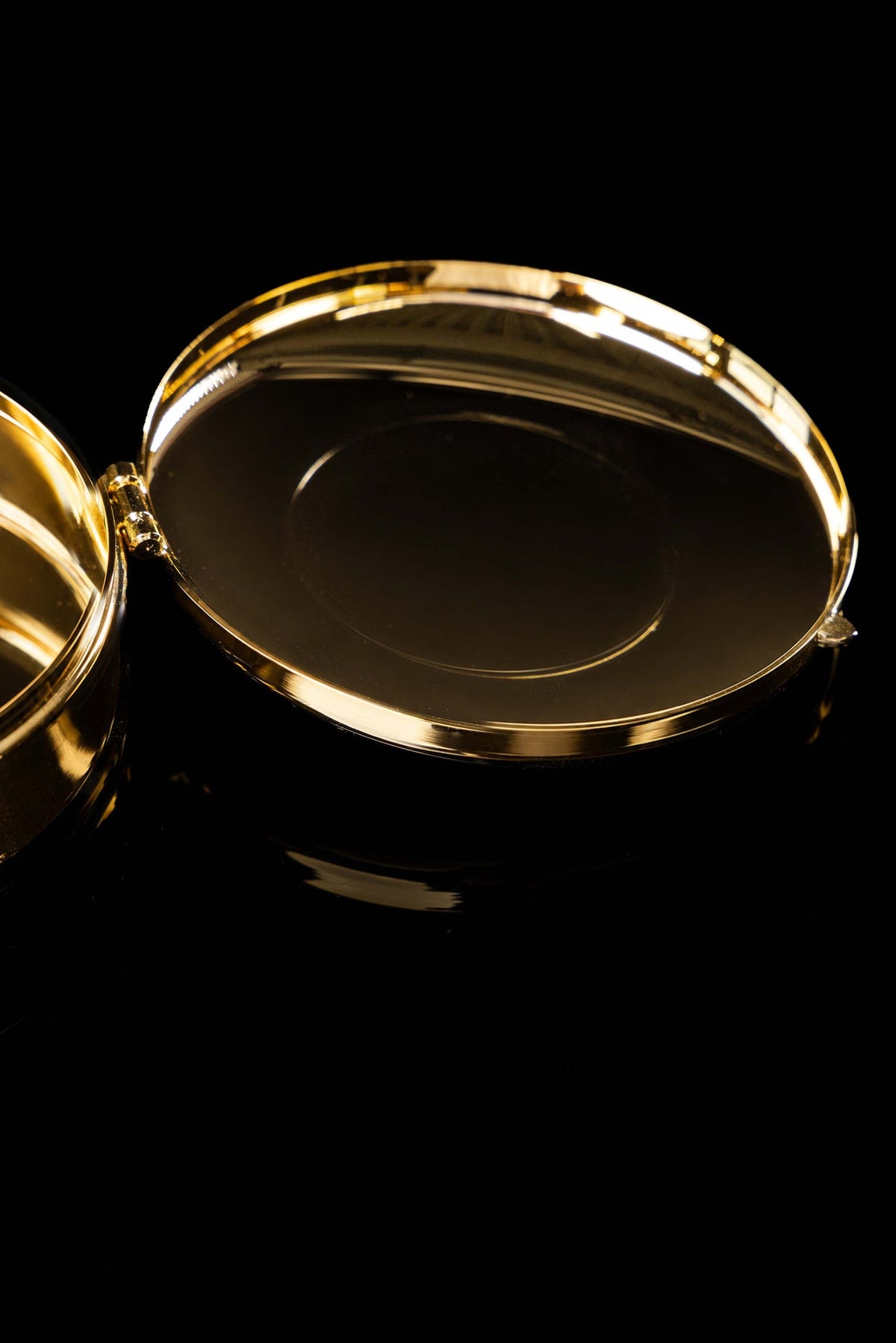 Gold-plated ciborium lid open, showing its plain inner surface