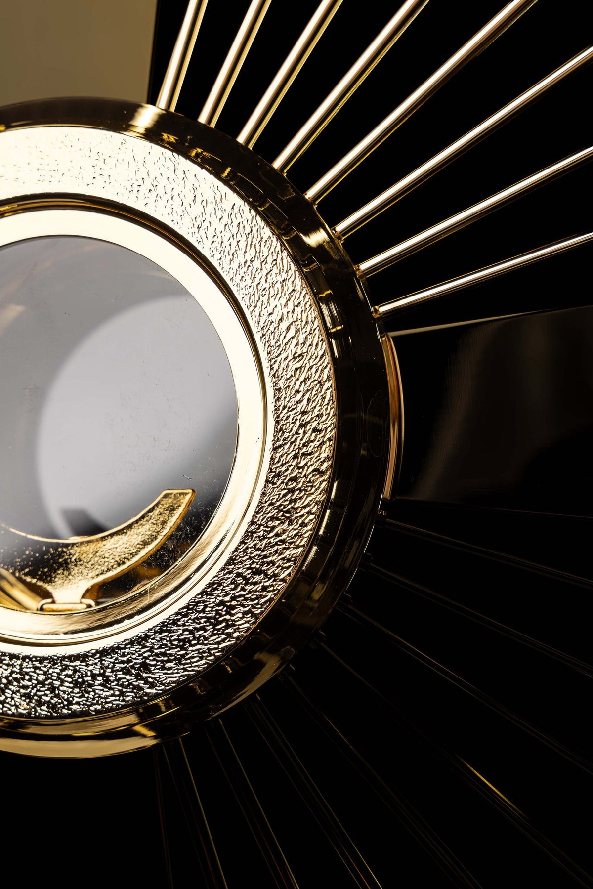 Gold-plated brass monstrance close-up of the textured frame, luna, and rays