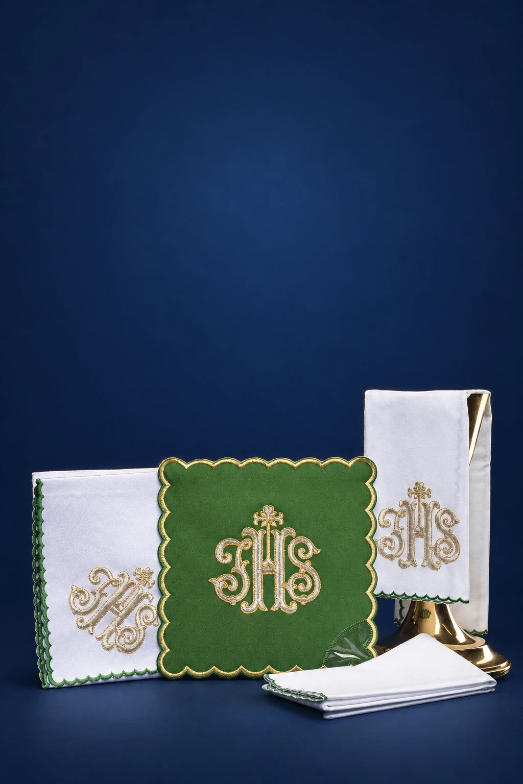 Embroidered altar linen set with green chalice pall and gold IHS motif, shown with folded linens and burse-like cover