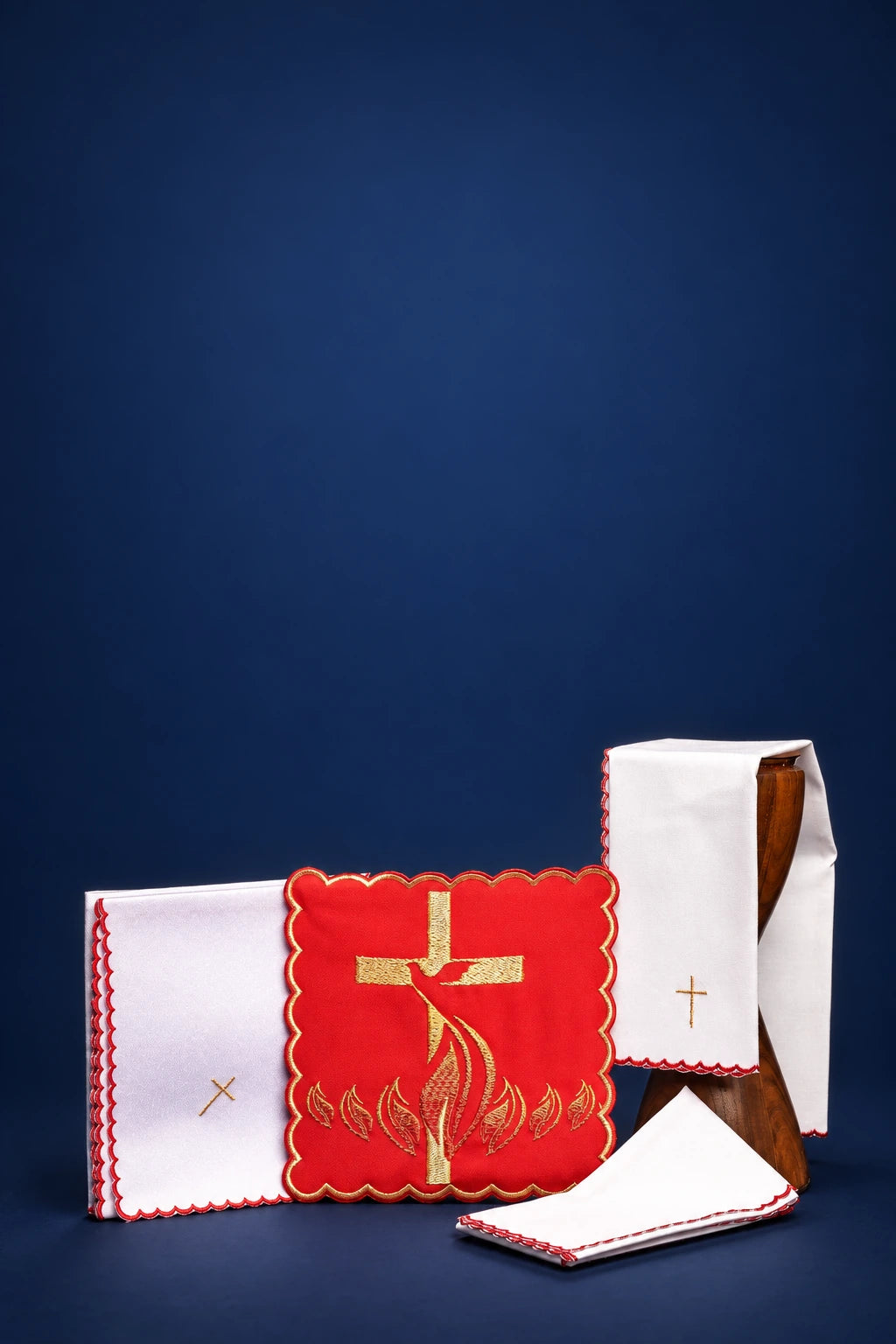 Embroidered altar linen set with red Holy Spirit motif and small gold crosses, shown folded and stacked
