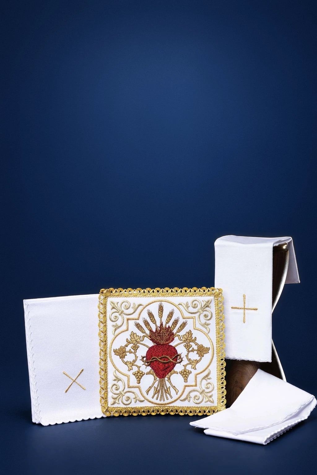 Embroidered altar linen set with Sacred Heart and gold trim, shown folded in a group view
