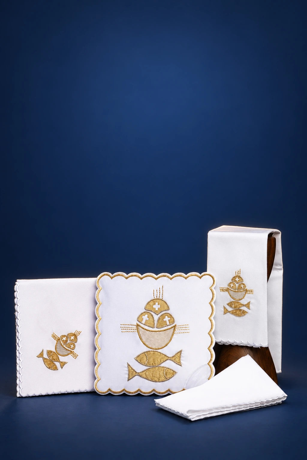 Embroidered altar linen set with scalloped cloths and bread-and-fish motifs shown folded