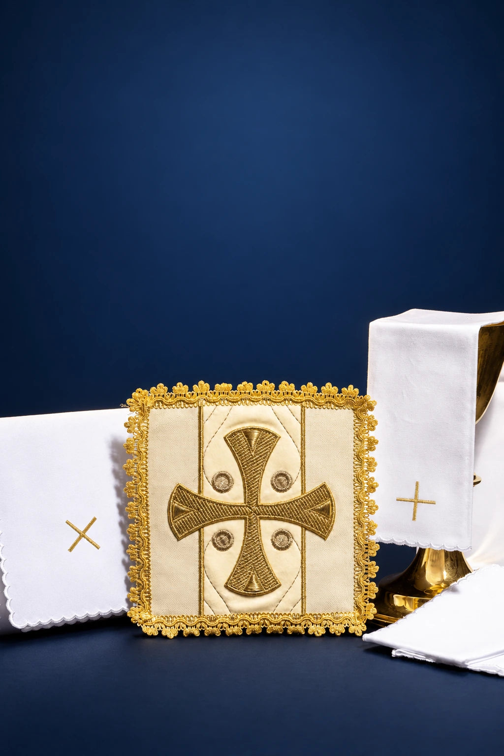 Embroidered altar linen set with square cloth showing a gold cross medallion and scalloped white pieces on velvet
