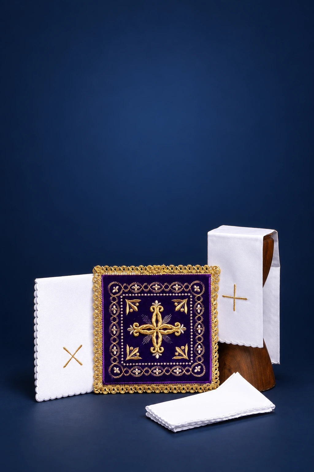Embroidered purple velvet chalice pall with gold cross, shown front view with folded altar linens