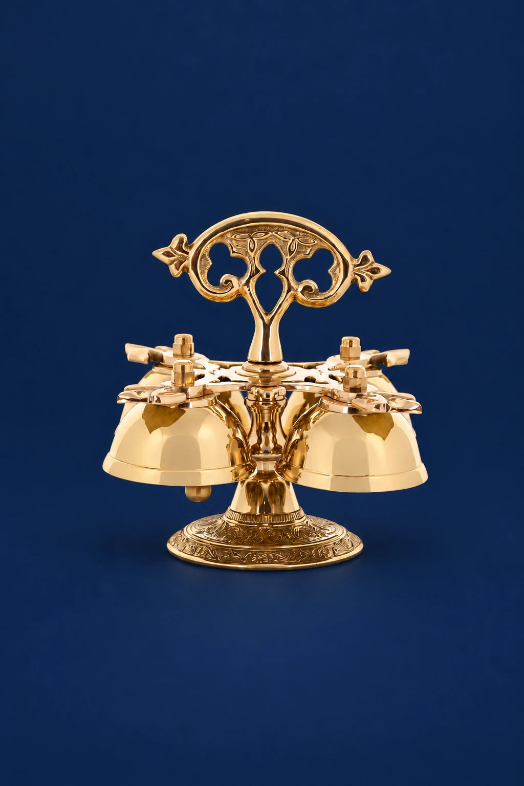 Four brass sanctus bells with ornate handle and engraved base, front view