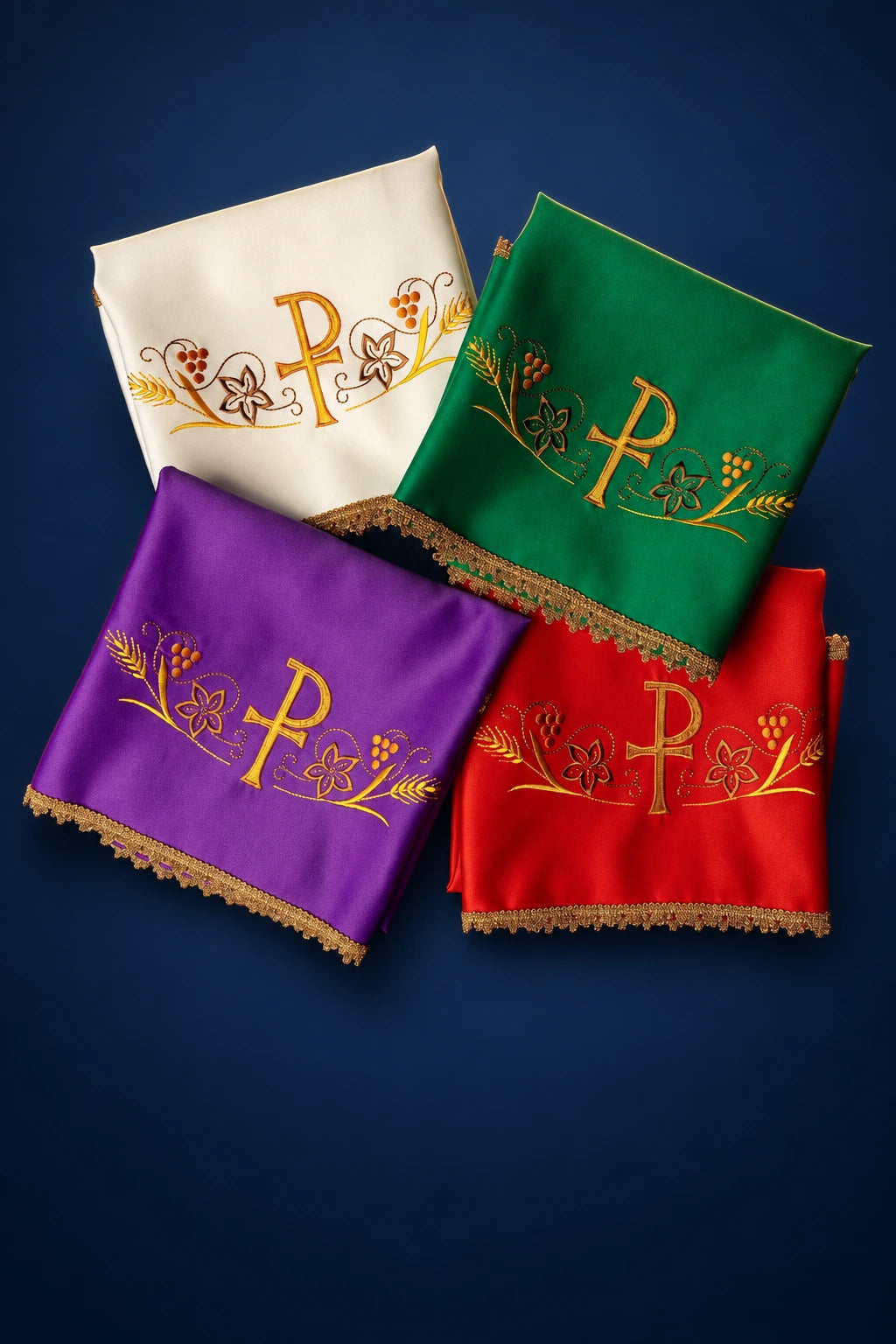 Four chalice veils in white, green, purple, and red with embroidered PAX and vine motifs, folded in a stack