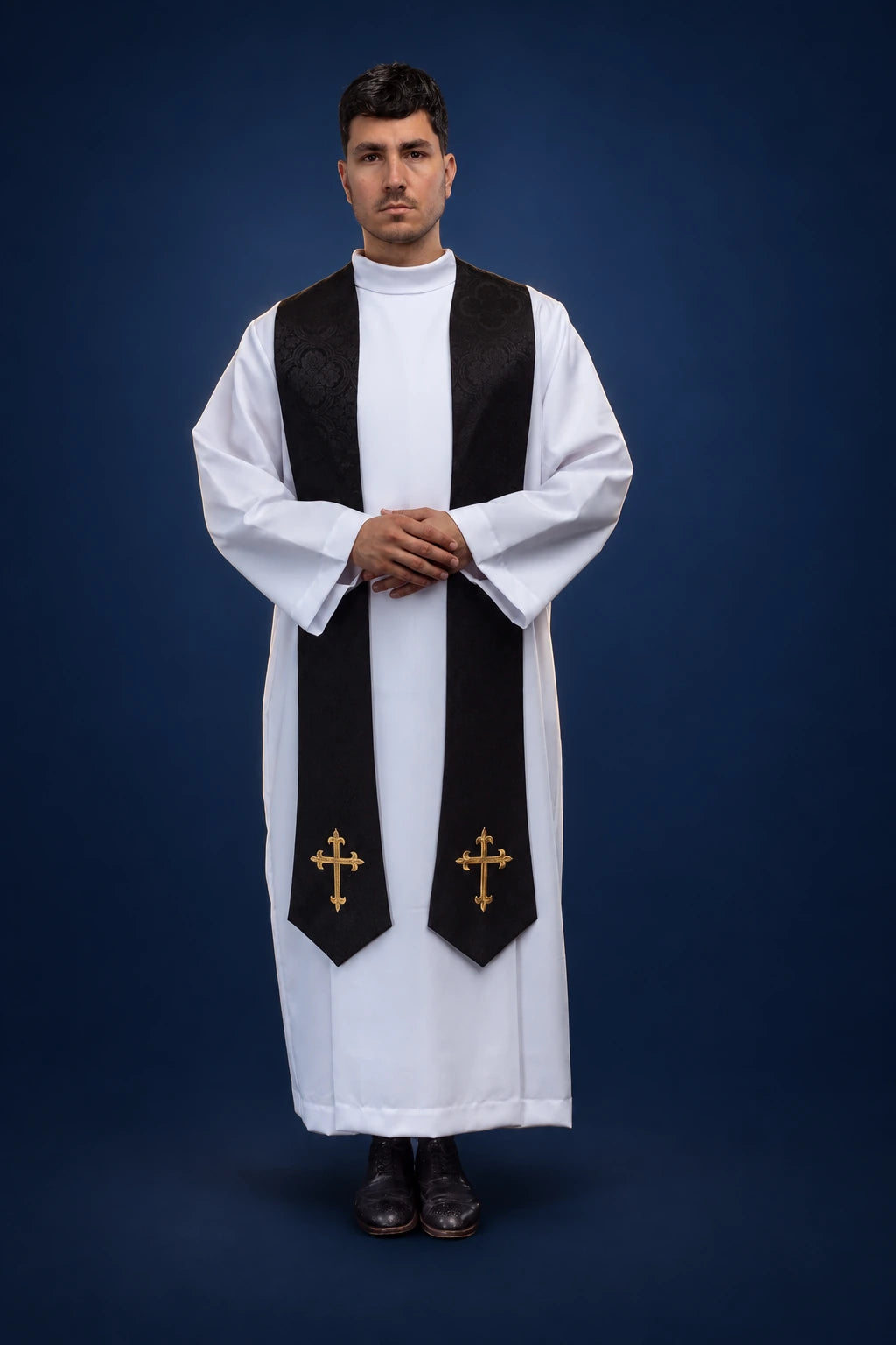Front view of a black Catholic stole with gold embroidered crosses over a white alb