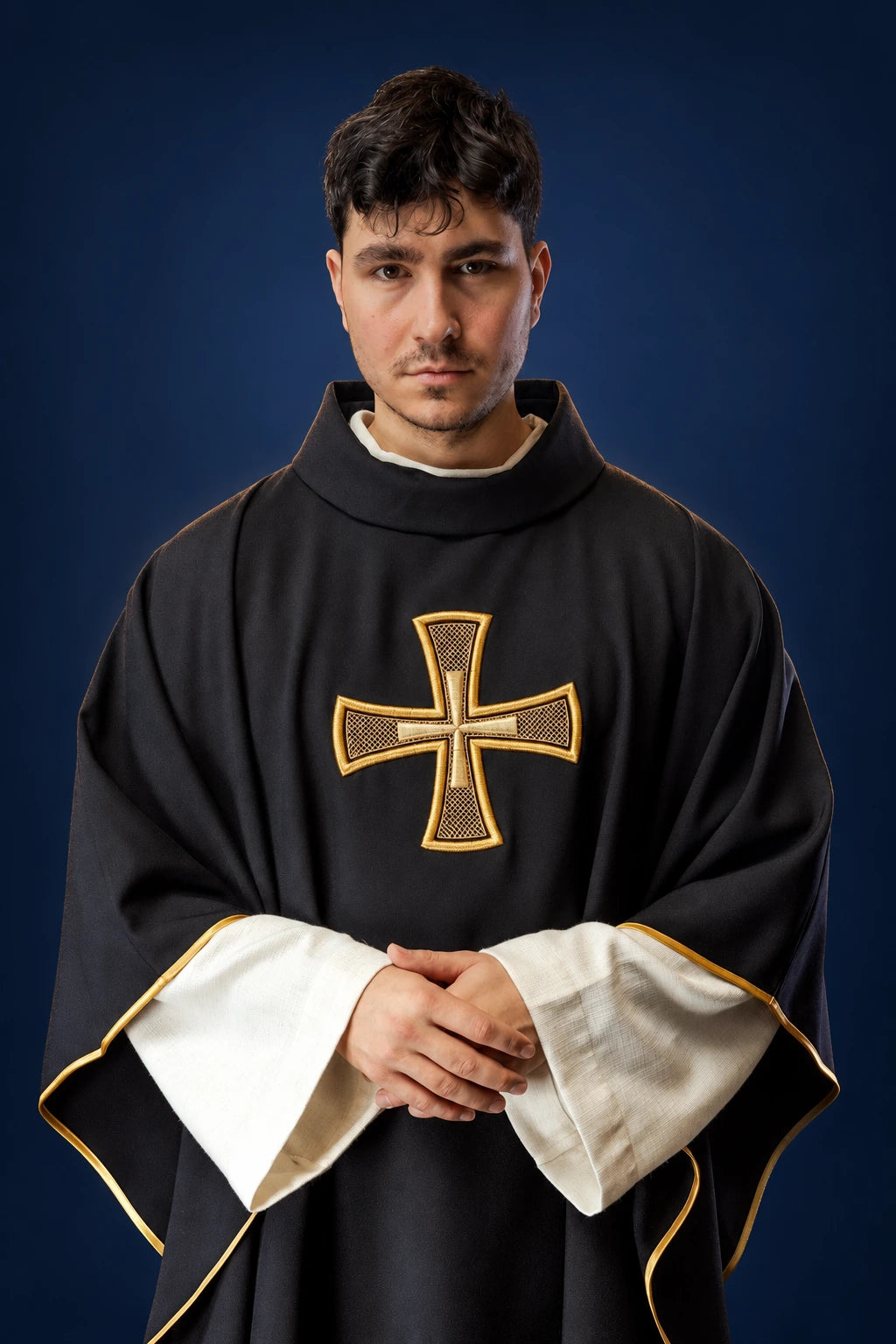 Front view of a black chasuble with a gold cross and white inner stole