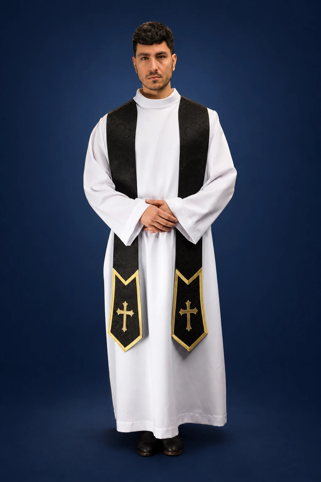 Front view of a black stole with gold cross motifs and pointed jacquard ends over a white alb
