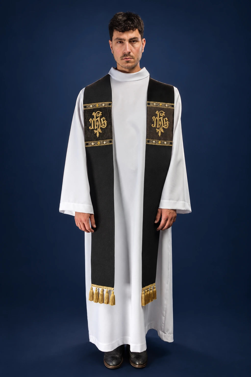 Front view of a black stole with gold IHS embroidery and fringe, worn over a white alb