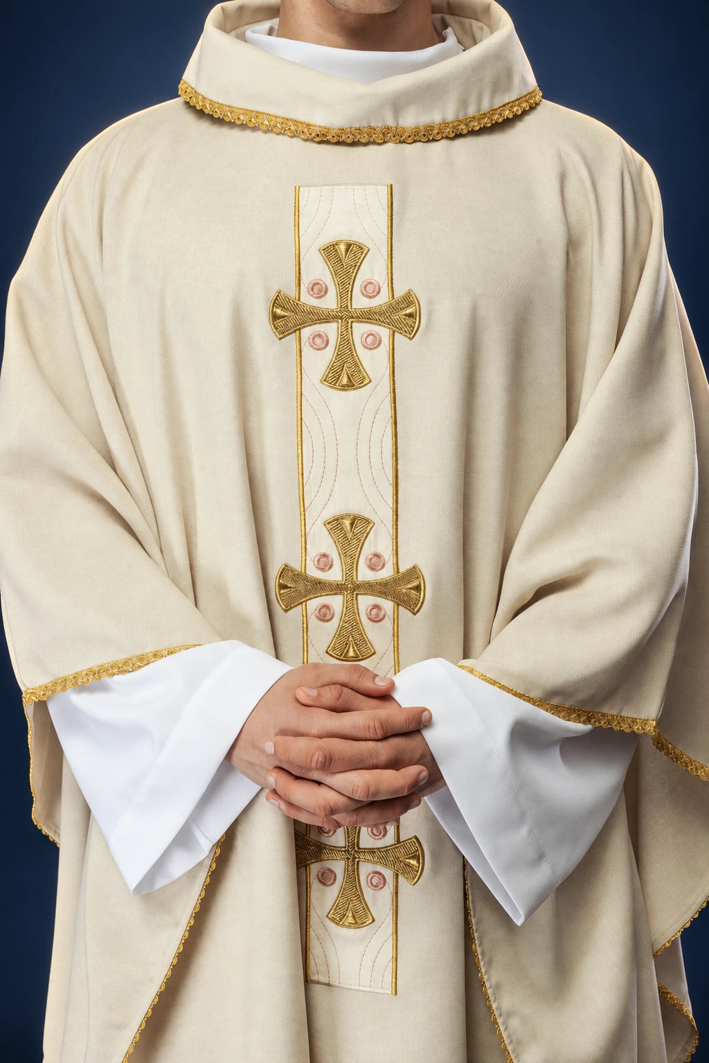 Front view of a cream chasuble with gold cross embroidery and ecru trim at the collar and sleeves