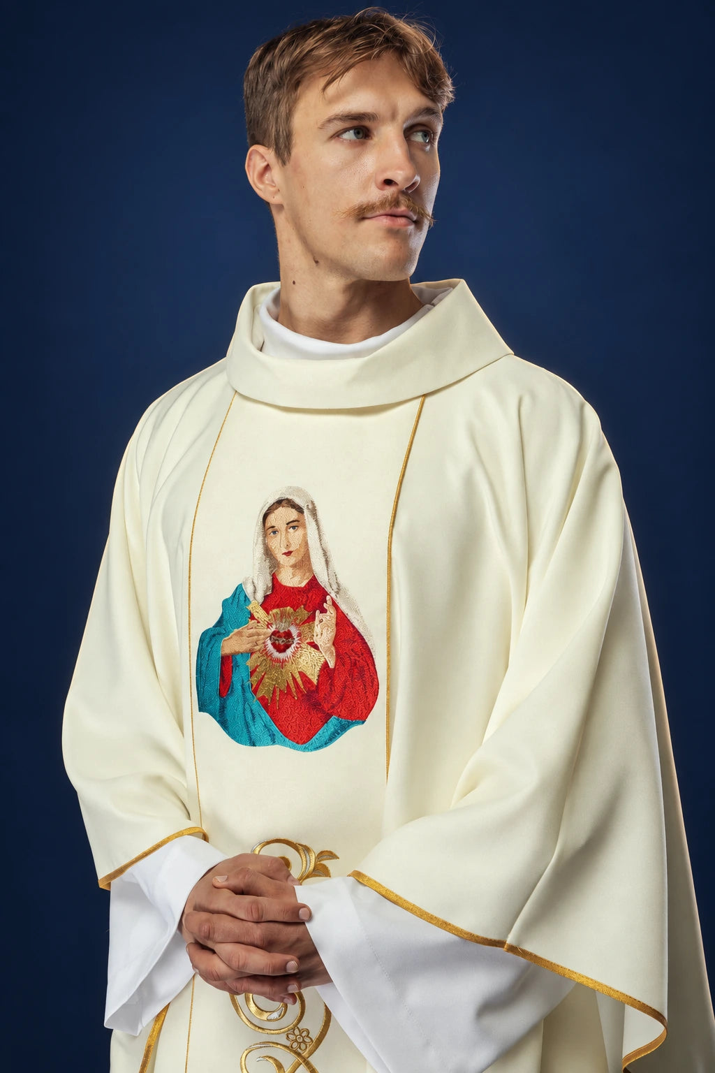 Front view of a cream chasuble with gold trim and an embroidered Heart of Mary on the chest