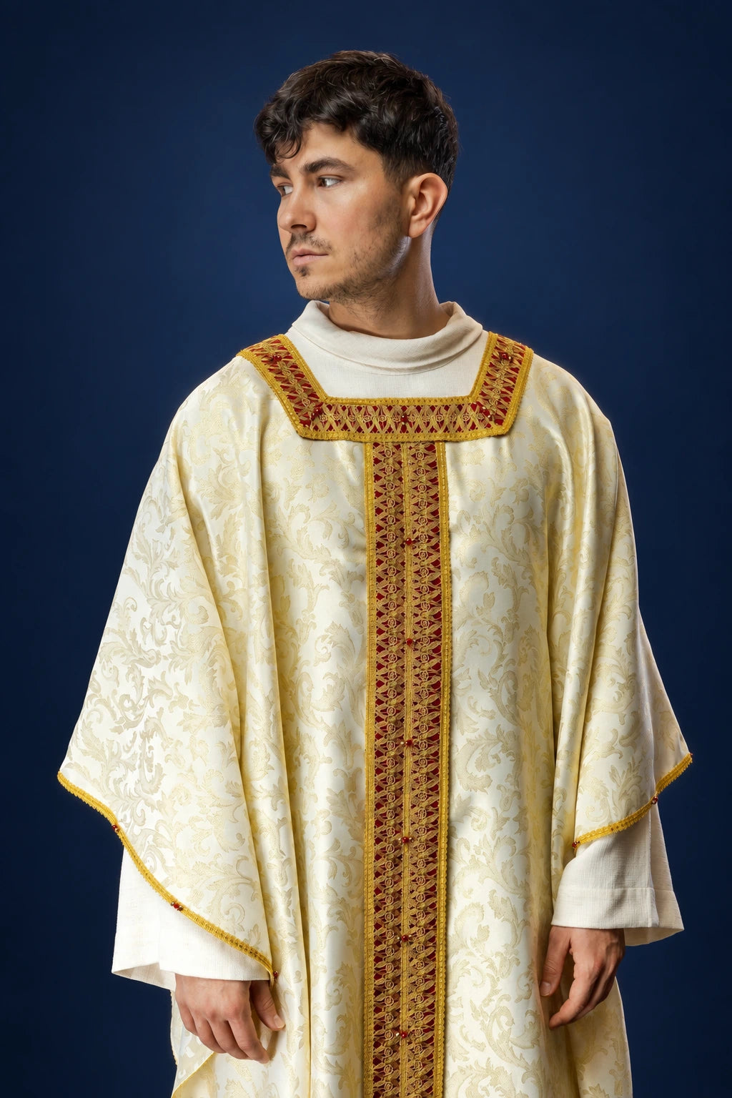 Front view of a cream chasuble with gold trim and a red-gold woven vertical band and collar panel